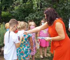 Rochester Rotary President, Kerry Norton, hands out books to School Street School 1st graders
