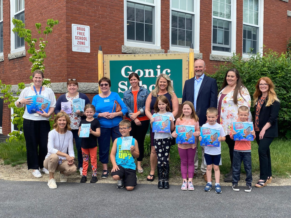 Students, staff members and representatives of Holy Rosary Credit Union (HRCU) and the Rochester Rotary Club stand with summer reading books outside the Gonic School. The books were donated by HRCU and the Rochester Rotary Club. (Photo Courtesy Rochester Public Schools)